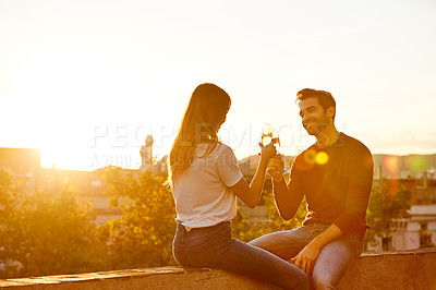 Buy stock photo Shot of a couple having champagne while on a rooftop date
