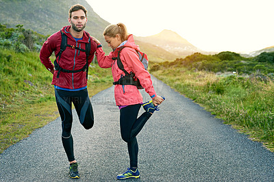 Buy stock photo Full length shot of a young couple warming up before their morning run
