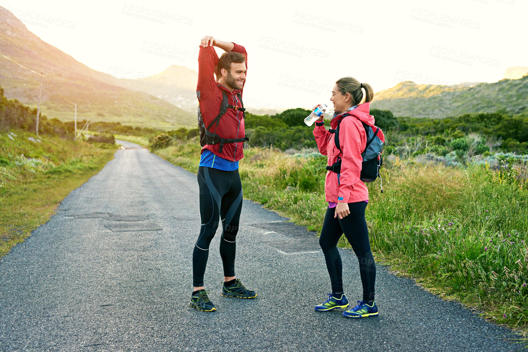 Buy stock photo Drink, fitness and stretching with happy couple outdoor for cardio training or workout preparation. Smile, warm up and water with people on mountain space for start of exercise or wellness routine