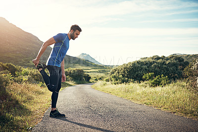 Buy stock photo Full length shot of a handsome young male athlete stretching before his run outdoors