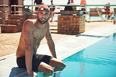 Buy stock photo Cropped portrait of a handsome young male swimmer sitting on the side of a pool