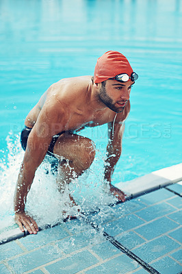 Buy stock photo High angle shot of a young male swimmer making his exit from the swimming pool