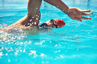 Buy stock photo Cropped shot of a handsome young male swimmer doing laps in a swimming pool