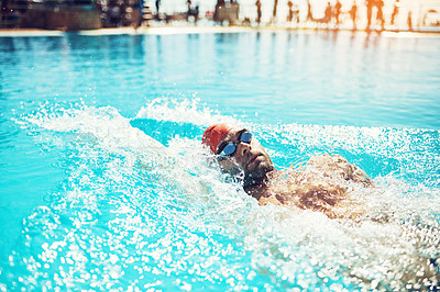 Buy stock photo Shot of a handsome young male swimmer doing backstroke in a swimming pool