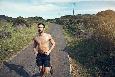 Buy stock photo High angle shot of a handsome young male athlete out for a morning run