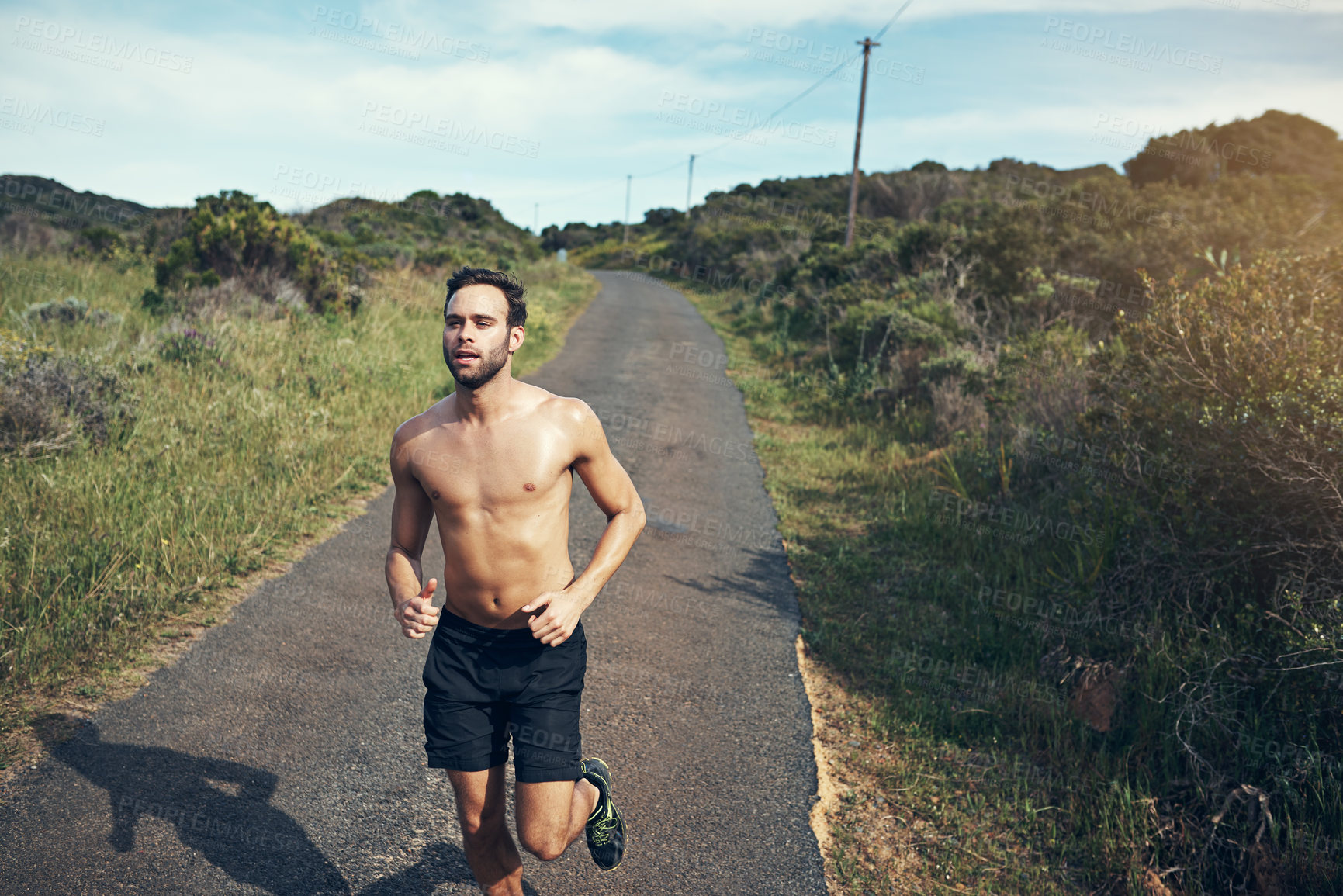 Buy stock photo High angle shot of a handsome young male athlete out for a morning run