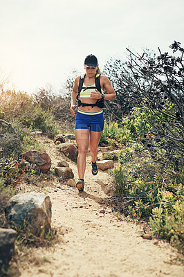 Buy stock photo Low angle shot of an attractive young female athlete out for a morning run