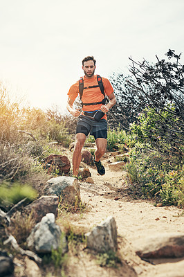 Buy stock photo Low angle shot of a handsome young male athlete out for a morning run