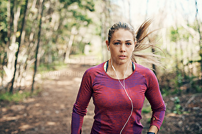Buy stock photo Cropped shot of an attractive young female athlete listening to music while out for a morning run