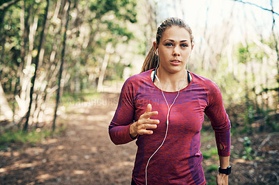 Buy stock photo Cropped shot of an attractive young female athlete listening to music while out for a morning run