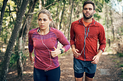 Buy stock photo Cropped shot of a young athletic couple listening to music while out for their morning run