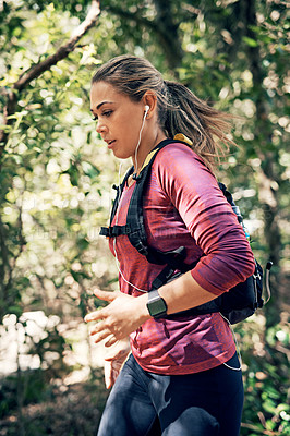Buy stock photo Cropped shot of an attractive young female athlete listening to music while out for a morning run