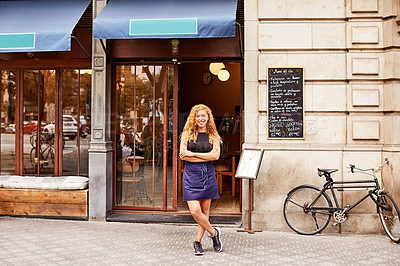 Buy stock photo Shot of a young woman standing in front of her coffee shop
