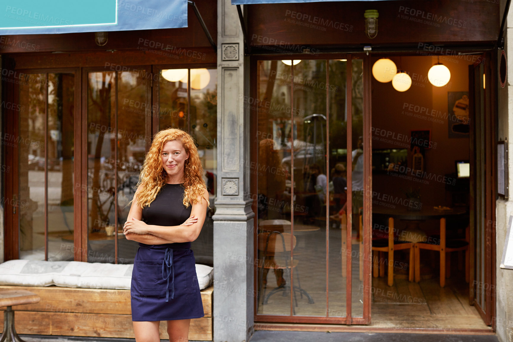 Buy stock photo Shot of a young woman standing in front of her coffee shop