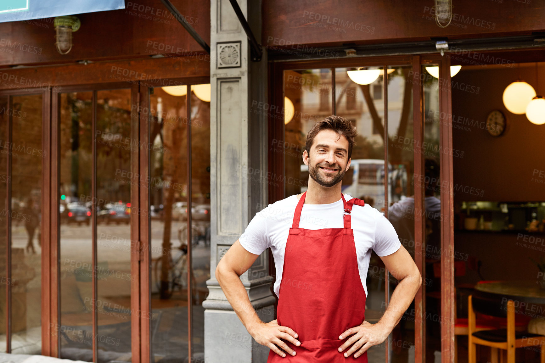 Buy stock photo Shot of a young man standing in front of his coffee shop