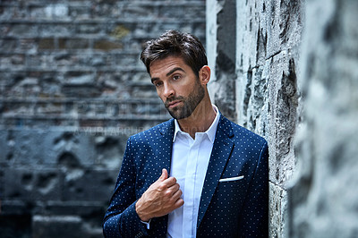 Buy stock photo Cropped shot of a handsome young businessman looking thoughtful while standing in an urban alleyway