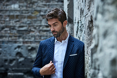 Buy stock photo Cropped shot of a handsome young businessman looking thoughtful while standing in an urban alleyway