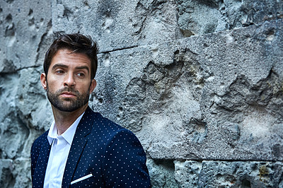 Buy stock photo Cropped shot of a handsome young businessman looking thoughtful while standing in an urban alleyway