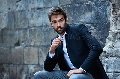 Buy stock photo Cropped shot of a handsome young businessman sitting in an urban alleyway