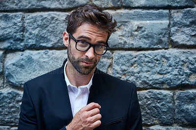 Buy stock photo Cropped portrait of a handsome young businessman standing against a brick wall in an urban alleyway