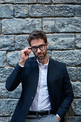 Buy stock photo Cropped portrait of a handsome young businessman standing against a brick wall in an urban alleyway