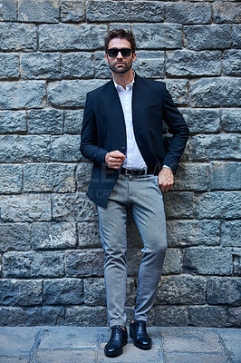 Buy stock photo Full length portrait of a handsome young businessman standing against a brick wall in an urban alleyway