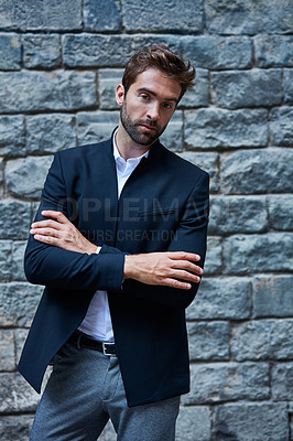 Buy stock photo Cropped portrait of a handsome young businessman standing against a brick wall in an urban alleyway