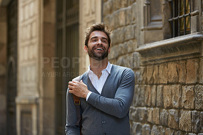 Buy stock photo Cropped shot of a handsome young businessman laughing while walking through an urban alleyway
