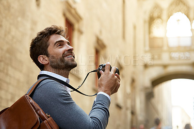Buy stock photo Cropped shot of a handsome young businessman taking photographs while overseas on a business trip