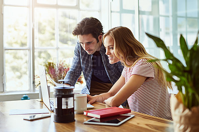Buy stock photo Shot of a focused young couple doing paperwork together while being seated next to a table at home