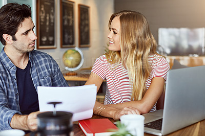 Buy stock photo Shot of a focused young couple doing paperwork together while being seated next to a table at home