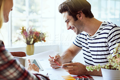 Buy stock photo Shot of a focused young couple drawing plans and choosing colors for the renovation of their house