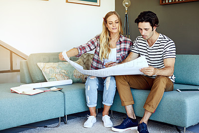 Buy stock photo Shot of a focused young couple drawing plans and choosing colors for the renovation of their house