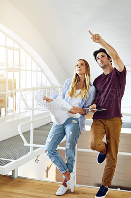 Buy stock photo Shot of a focused young couple drawing plans and choosing colors for the renovation of their house
