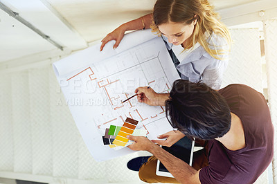 Buy stock photo High angle shot of a focused young couple drawing plans and choosing colors for the renovation of their house
