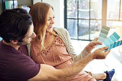 Buy stock photo Shot of a young man choosing color swatches with his pregnant wife to decide the color of the room