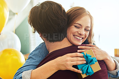 Buy stock photo Shot of a young couple exchanging gifts at home