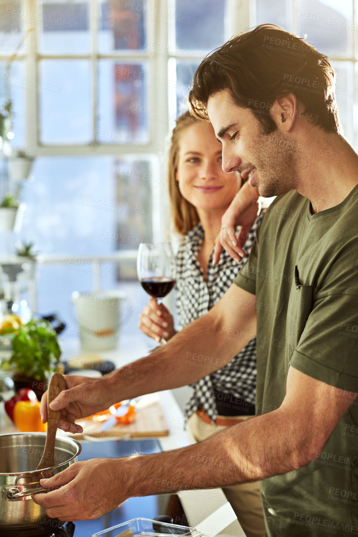 Buy stock photo Happy, couple and cooking in kitchen with red wine, support partner and assistance for lunch recipe. People, dating and meal preparation in home with alcohol drink, relationship or smile for wellness