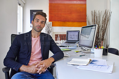 Buy stock photo Shot of a handsome young man sitting in his office