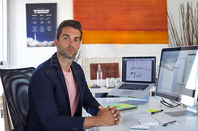 Buy stock photo Shot of a handsome young man sitting in his office