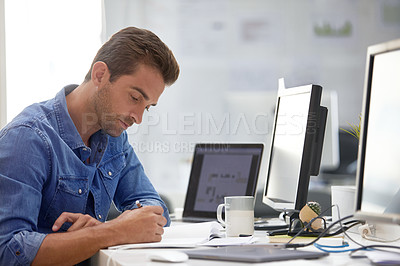 Buy stock photo Shot of a handsome young man working in an office