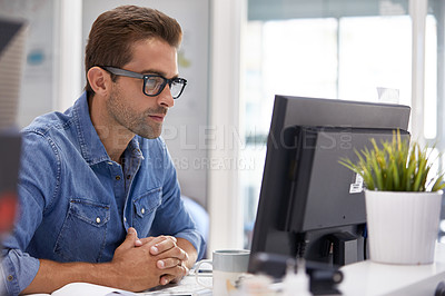 Buy stock photo Shot of a handsome young man working in an office