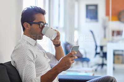 Buy stock photo Cropped shot of a young man using his cellphone in his office