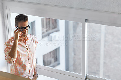 Buy stock photo Shot of a young businessman talking on his cellphone