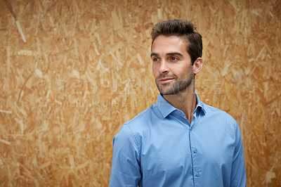 Buy stock photo Cropped shot of a handsome young man posing against a wooden wall
