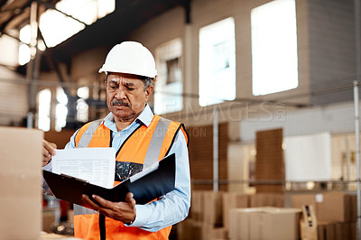 Buy stock photo Shot of a mature man doing inspections in a warehouse