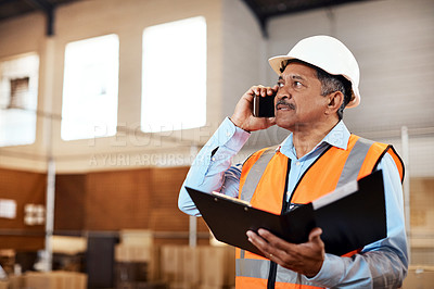 Buy stock photo Shot of a mature man using a smartphone while working in a warehouse