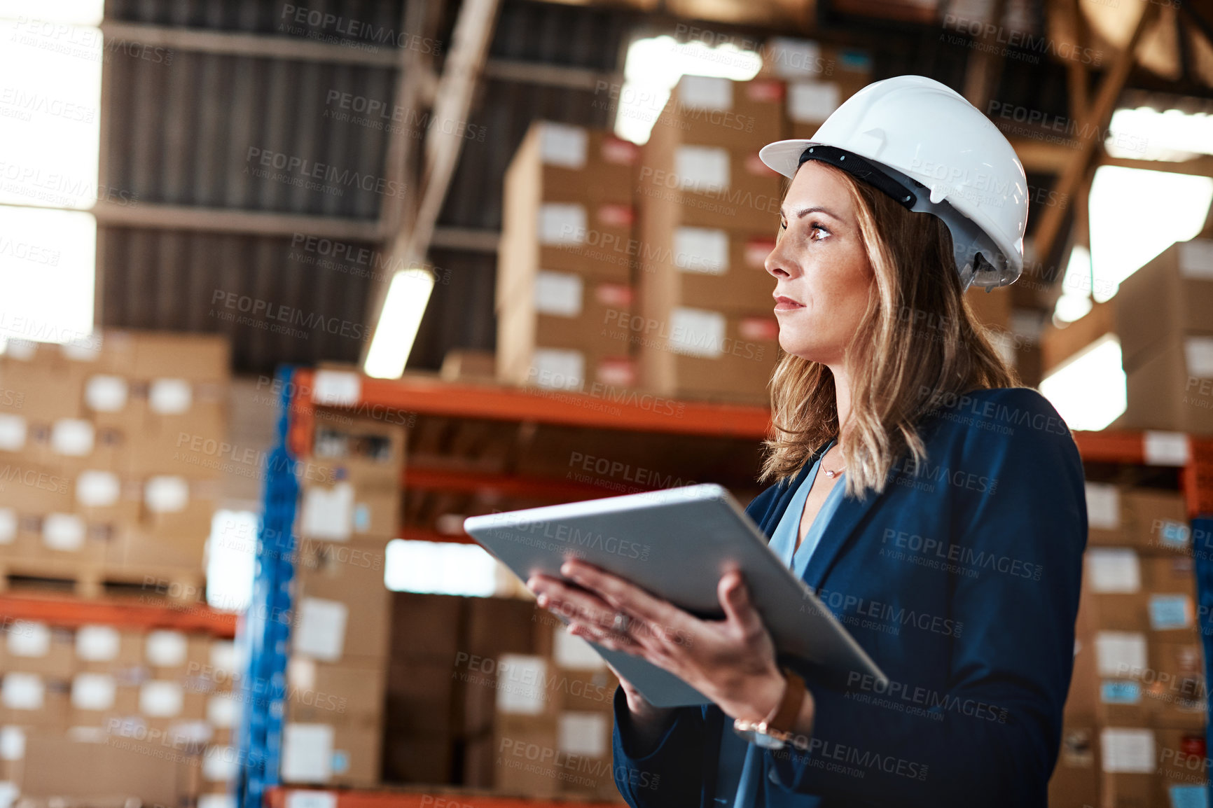 Buy stock photo Shot of a young woman using a digital tablet while working in a warehouse