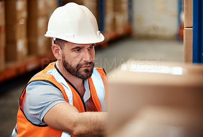 Buy stock photo Shot of a young man working in a warehouse
