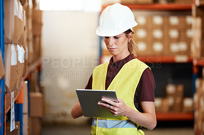 Buy stock photo Shot of a young woman using a digital tablet in a warehouse